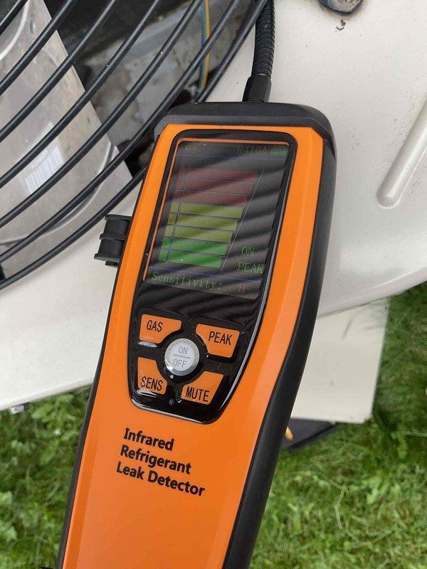 Diagnosed AC system exhibiting no cooling and found refrigerant leak at condenser coil with infrared leak detector, verified by visible water dripping into furnace. Replaced defective condenser coil to restore proper system operation and cooling capacity.