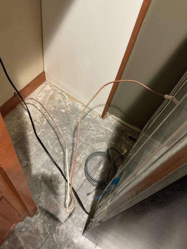 Completed chase installation to connect water supply line for vanity. Documented unfinished area with exposed concrete flooring and plumbing runs. Shower installation pending compatible parts. Two toilets remain to be installed pending completion of flooring work.