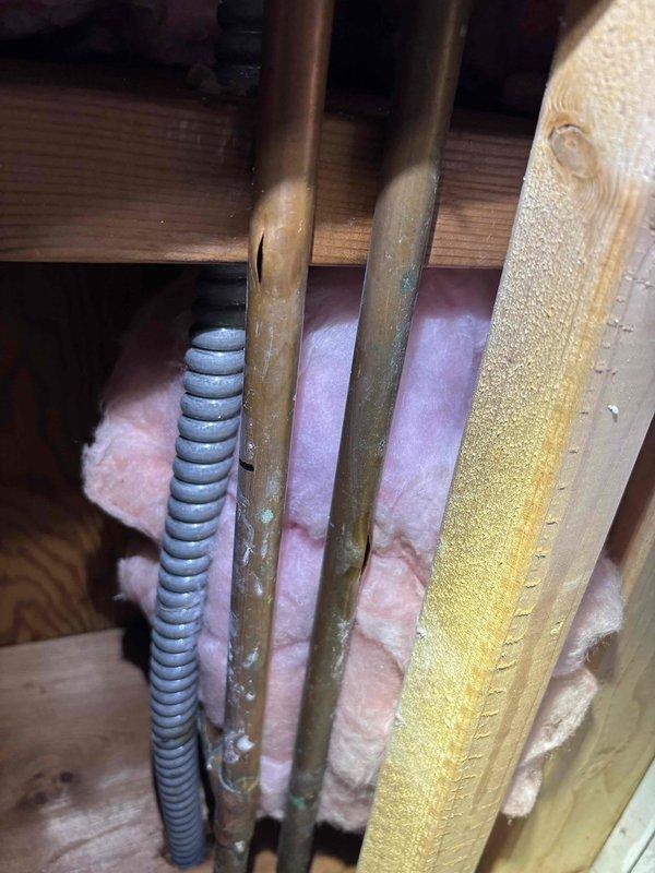 Identified recurring freeze-related split in thin copper water supply line located dangerously close to exterior wall. Replaced damaged copper piping with PEX tubing, rerouting kitchen, laundry, and outdoor faucet supply lines to maintain appropriate distance from exterior wall to prevent future freezing issues.