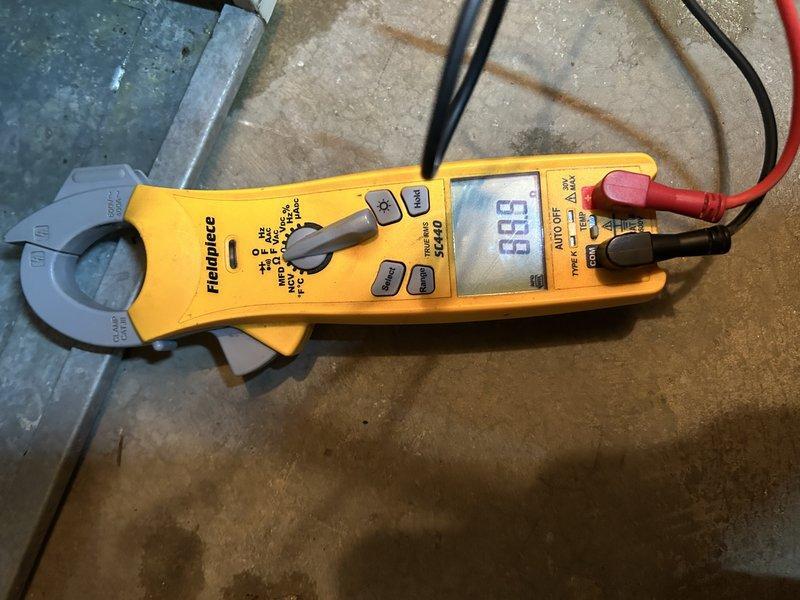 Performed diagnostic inspection on 15-20 year old natural gas forced air furnace following customer's new enrollment in Family Rewards program. Identified and cleared plugged condensate drain that was causing intermittent operation issues as water would accumulate and trigger shutdown until drained. Conducted comprehensive maintenance including heat exchanger inspection and electrical component testing with multimeter verification. Replaced aging thermostat with difficult buttons. System now operating normally with proper drainage.