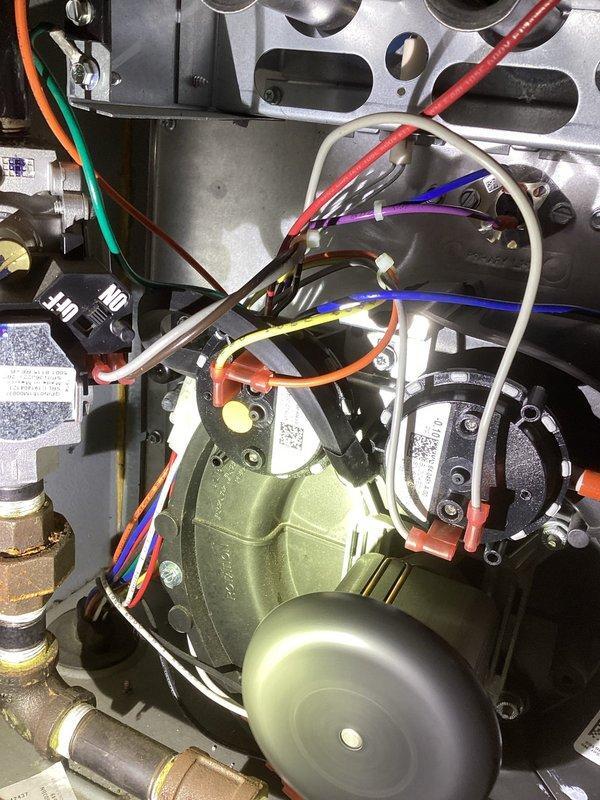 Diagnosed and resolved no-heat condition on Goodman furnace displaying lockout code due to excessive retries. Found water trapped in pressure switch hose due to improper routing, causing switch failure. Corrected hose routing to eliminate water trap and verified proper operation for 20 minutes with no fault codes. Noted presence of recall blower pressure switch update kit board already installed on unit.