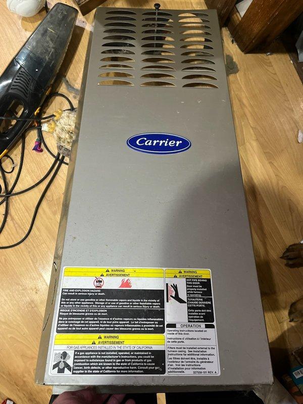 Diagnosed Carrier furnace failure due to seized blower motor preventing proper heat distribution. Performed system inspection finding severely clogged air filter and verifying functionality of flame sensor, ignitor, and burners. After cycling the furnace, confirmed blower wheel inoperability requiring blower motor replacement. Provided customer with replacement options.