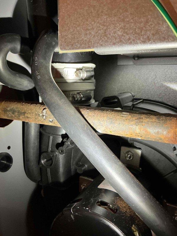 Responded to customer report of water pooling in Lennox furnace cabinet (1-year-old unit). Discovered water accumulation in front left corner with no visible active leaks. Performed maintenance by tightening hose clamps on draft motor exhaust collar and securing draft motor bolts. Dried affected area and monitored for continued leakage; customer advised to document if issue recurs.