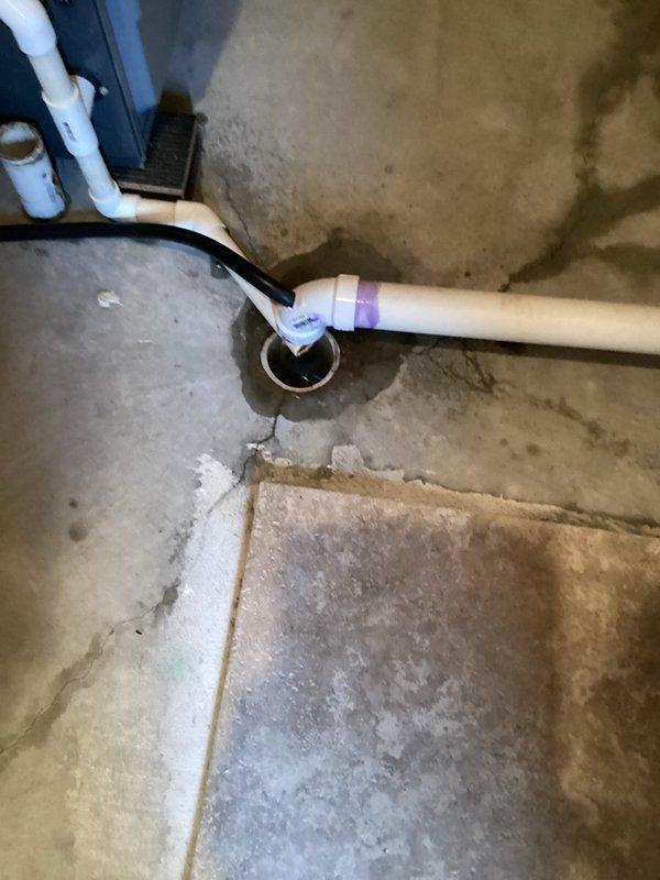 Responded to emergency service call for a blocked sump pump line at residential property. Upon inspection, discovered the main line to septic system was frozen. Performed initial assessment of electrical panel and plumbing connections, examining the PVC piping configuration at the floor drain. Referred customer to specialized drain cleaning company as the issue required dedicated equipment for frozen septic lines.
