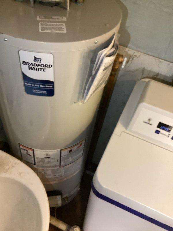 Investigated water leak report in basement near water heater. Performed comprehensive testing of all fixtures under high water loads but could not replicate the leak. Discovered water heater temperature was set excessively high at 150°F; adjusted to recommended 120°F to resolve potential pressure/expansion issues. Recommended installation of expansion tank to prevent future leaks, but customer declined this option.