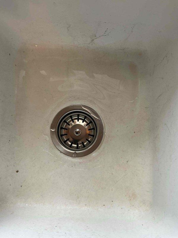 Responded to a clogged kitchen sink drain. Upon inspection, found the P-trap assembly completely obstructed with debris. Removed and cleaned out the trap components, then utilized a drain auger to clear an additional blockage located approximately one foot into the horizontal drain line. Drainage restored to full functionality.