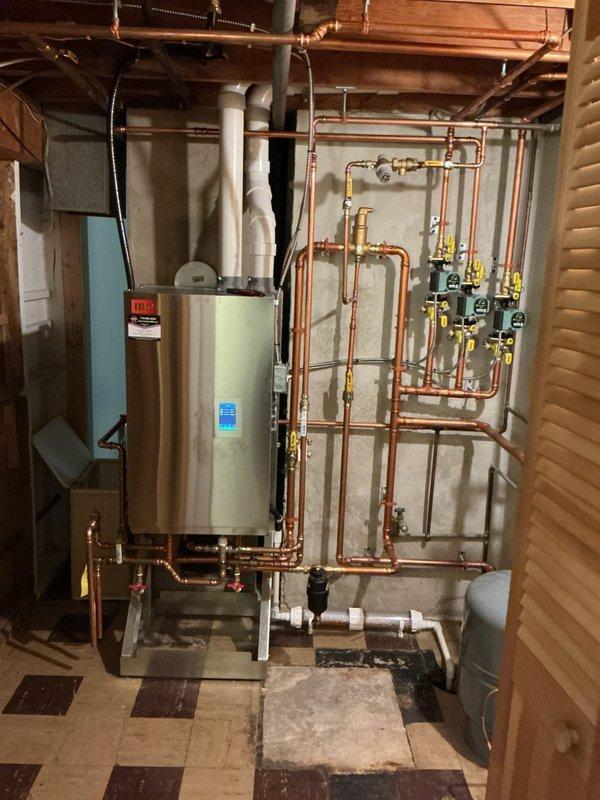 Responded to callback for insufficient hot water temperature at fixtures throughout residence. Upon arrival, measured water temperatures at multiple fixtures, confirming temperatures between 112-115°F, with shower and main bath showing inconsistent delivery. Investigation revealed mixing valve installed during previous recall service in January had never been properly adjusted and was set at full closed position, limiting output to 115°F. Adjusted mixing valve to proper setting and reconfigured selection parameters on IBC tankless water heater to optimize performance with mixing valve installation. Shower valve cartridge identified as additional source of temperature inconsistency; estimate provided for cartridge replacement to resolve remaining fluctuation issues and achieve desired water temperature for bathing applications.