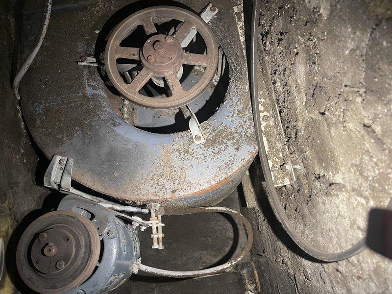 Responded to service call for non-functioning air handler in attic. Diagnosed seized blower motor as evidenced by frozen shaft and inability to rotate. Removed belt and pulley assembly for further inspection. Documented extensive rust and dust accumulation on housing components. Submitted motor replacement specifications to parts department for customer estimate.