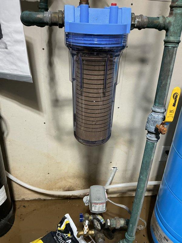 Responded to service call for water leakage from disconnected hoses of an outdoor wood burner in the furnace room, causing flooding and potential mold issues. Assessed the situation and advised customer to seal the basement opening and install drain tile outside to properly manage water intrusion. Attempted to install whole house water filter but had incorrect size; replacement filter has been ordered and will be shipped directly to customer's residence.