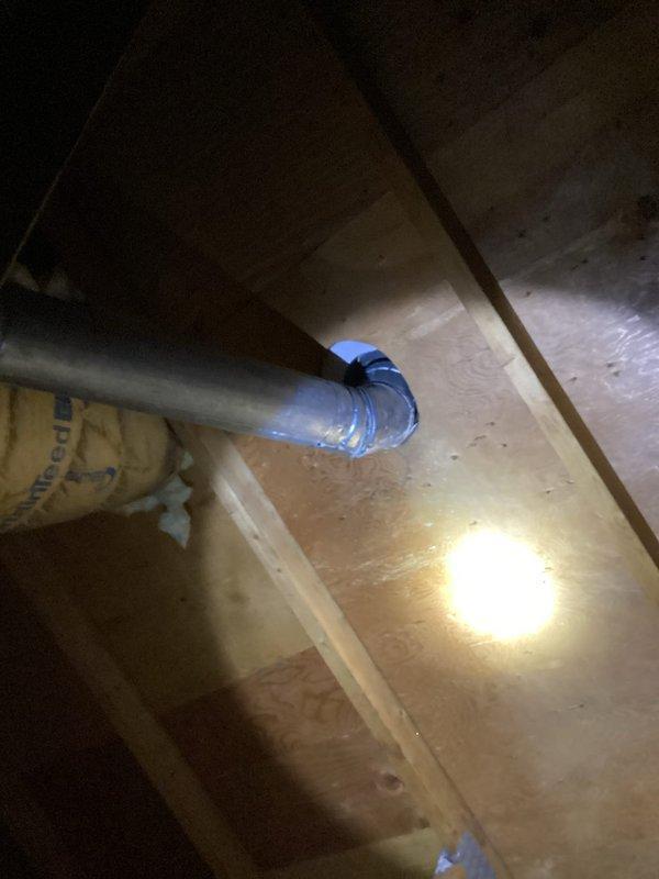 Inspected water heater venting system in attic and identified flue pipe detachment at 45-degree connection point at roof penetration. Documented condition with photos showing exposed metal ductwork with compromised blue connection collar. Scheduled follow-up service with heating technicians to properly reconnect and secure the flue system.