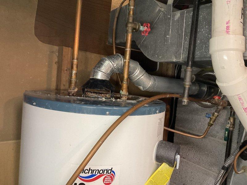 Diagnosed 15-year-old Richmond 40-gallon natural gas water heater with active leak from tank top. Unit (2004 model) determined to be non-repairable due to age and tank deterioration. Provided options for replacement including customer-supplied heater option. Existing installation includes copper supply lines, atmospheric venting, and standard gas connection.