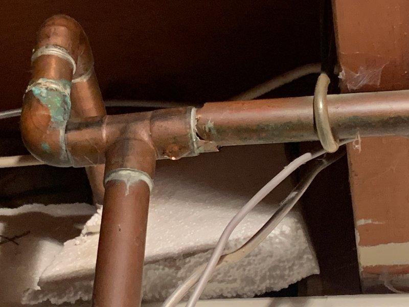 Diagnosed and repaired a copper pipe leak located between the main shut-off valve and water softener. Shut off water supply, cut out the deteriorated section of copper piping showing significant oxidation and corrosion at the joints, and installed new copper pipe with properly soldered connections to restore system integrity.