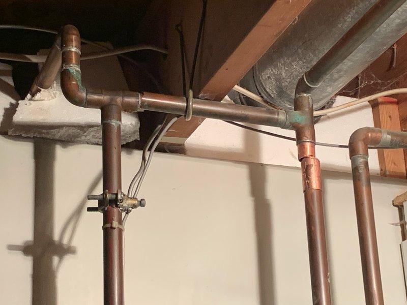 Diagnosed and repaired a copper pipe leak located between the main shut-off valve and water softener. Shut off water supply, cut out the deteriorated section of copper piping showing significant oxidation and corrosion at the joints, and installed new copper pipe with properly soldered connections to restore system integrity.