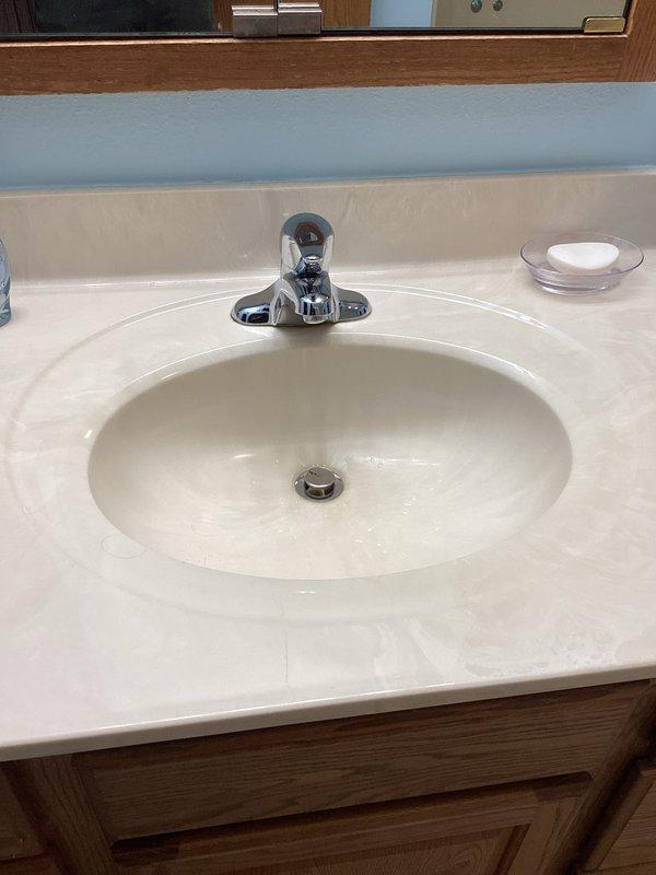 Performed comprehensive plumbing inspection of residential property, examining water treatment system consisting of dual black tanks and water softener setup with adequate salt supply. Inspected water heater for proper connections and safety compliance, and evaluated bathroom fixtures including sink, faucet, and drain for functionality and condition, with all components appearing to be in good working order.