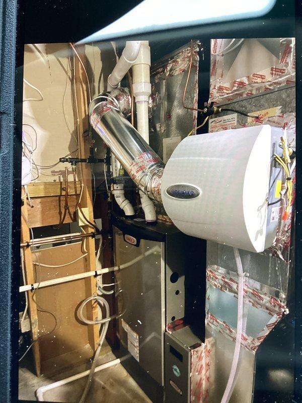 Responded to service call for humidifier valve replacement. Previous technician was unable to complete the installation of a 1/4" line for the residential humidifier due to leaking valve and lack of proper fittings. Successfully replaced the failed humidifier valve on the HVAC system mounted to the furnace ductwork in the utility area, resolving the leak issue and ensuring proper operation.