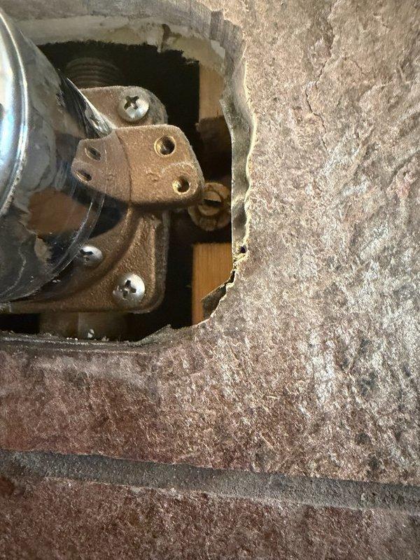 Successfully replaced leaking shower valve that was exhibiting leakage from the valve body shutoffs. Removed damaged section of wall to access the valve assembly, then installed new shower cartridge and handle with chrome escutcheon plate, restoring proper function to the fixture.