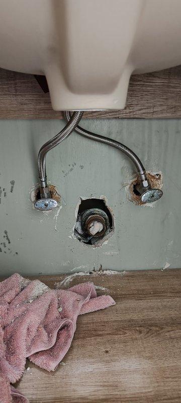 Responded to bathroom sink drain connection issue following vanity replacement. Upon arrival, found heavily corroded 1-1/4" galvanized drain pipe protruding from wall with male threads that would not accept standard trap connections. Previous installation had been improperly configured with PVC connected directly to the deteriorated galvanized pipe. Installed 1-1/4" x 1-1/2" Mission band coupling to adapt the corroded galvanized stub-out, then connected trap adapter and new 1-1/4" P-trap assembly. Completed installation of customer-supplied drain assembly to vanity sink. Tested system for proper drainage and verified no leaks at all connection points.