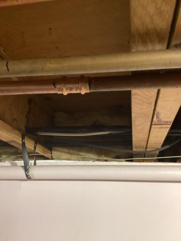 Responded to basement water leak in 3/4" copper supply line running from kitchen sink to main water line. Homeowner had previously attempted repair by cutting out damaged section but was unable to achieve proper solder joints. Removed homeowner's failed repair work and prepared pipe ends. Installed 2 feet of new 3/4" copper tubing with two couplings, properly soldered all connections, pressure tested system, and restored water service. All joints holding securely with no leaks detected.