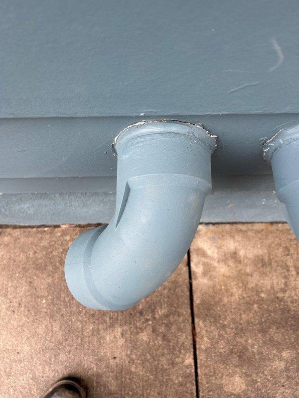 Repaired damaged water heater venting at exterior wall penetration as part of warranty service from recent installation. Applied silicone sealant to exterior vent connection to prevent water intrusion and ensure proper venting function.