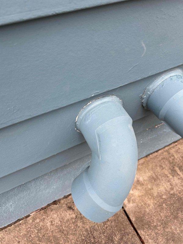 Repaired damaged water heater venting at exterior wall penetration as part of warranty service from recent installation. Applied silicone sealant to exterior vent connection to prevent water intrusion and ensure proper venting function.