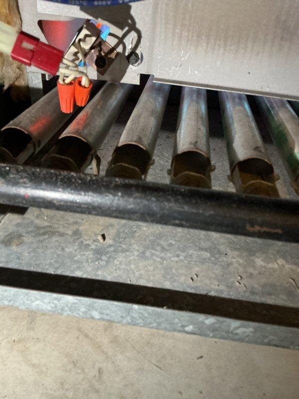 Responded to service call for boiler failure caused by a pressure valve malfunction that resulted in flooding and steam damage. Replaced high limit control and roll out switch to restore system safety functionality. Documented repair with photos of heat exchanger assembly and burner tubes with associated control wiring.