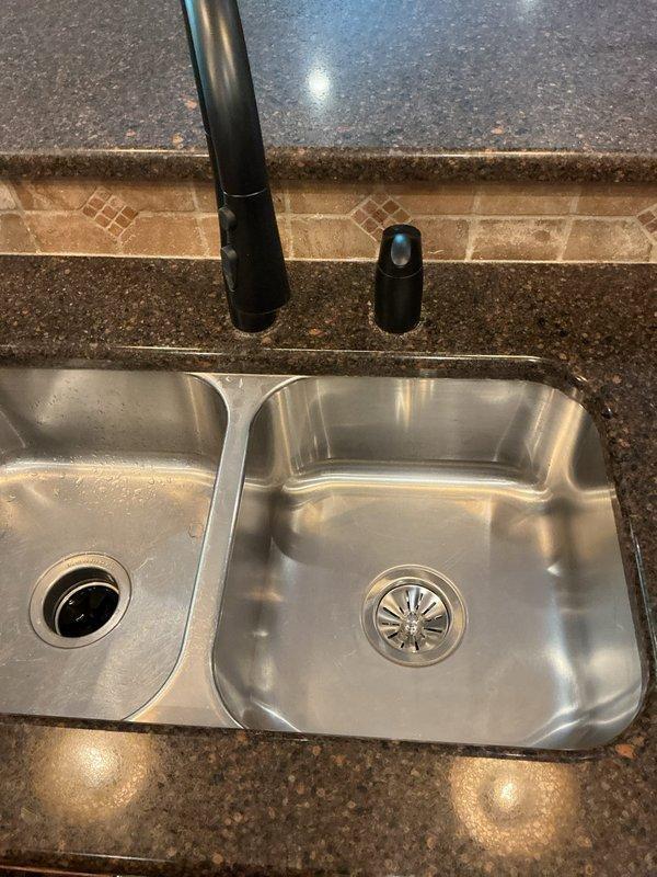 Completed chase installation to connect water supply line for vanity. Documented unfinished area with exposed concrete flooring and plumbing runs. Shower installation pending compatible parts. Two toilets remain to be installed pending completion of flooring work.