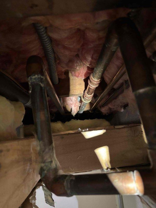 Identified recurring freeze-related split in thin copper water supply line located dangerously close to exterior wall. Replaced damaged copper piping with PEX tubing, rerouting kitchen, laundry, and outdoor faucet supply lines to maintain appropriate distance from exterior wall to prevent future freezing issues.