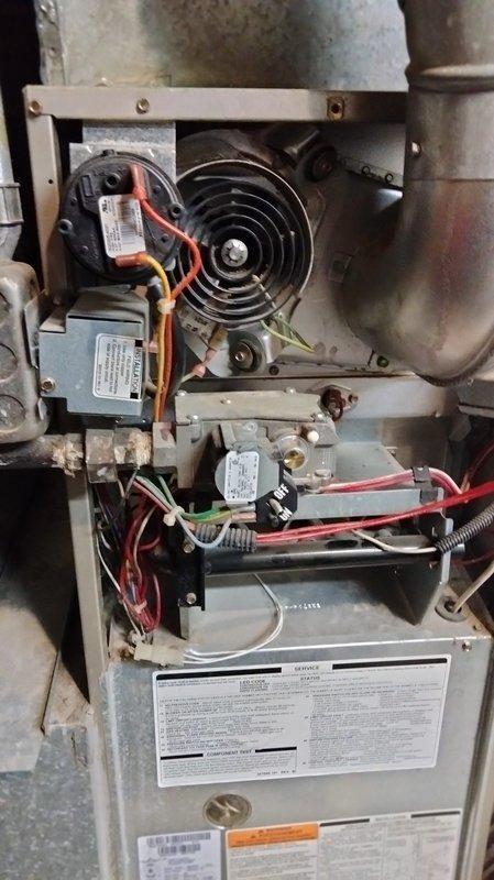 Responded to service call for an 18-year-old Carrier furnace experiencing intermittent operation with error codes 12, 13, and 33. Diagnostic inspection revealed draft inducer motor with failing bearings causing squealing and scraping noises, oil leakage from blower motor, out-of-spec blower capacitor, and high limit switch activation despite low temperature readings (approximately 120°F). Heat exchanger inspection showed no cracks but significant temperature stress and rust formation. Reviewed replacement options with homeowner due to multiple component failures and age of system.