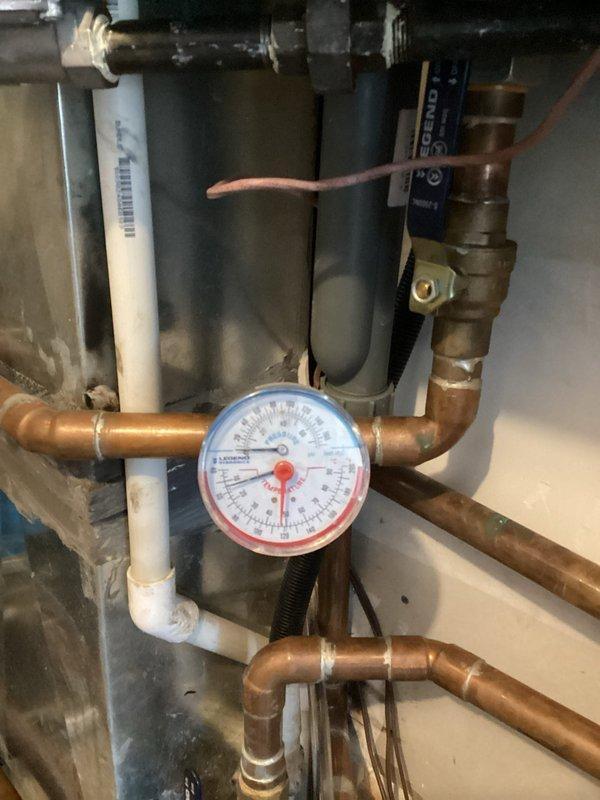 Responded to no-heat call for aging boiler system showing Low Water Pressure error. Utilized transfer pump to replenish water in the closed hydronic heating system, which services in-floor heating on lower level and portions of upper floor. During diagnostics, identified water leakage from manifold zone actuator requiring replacement, along with evidence of water damage to additional components. Recommended replacement of upstairs manifold pump flange and faulty pressure gauge. Restored system pressure to operational levels and provided repair estimates.