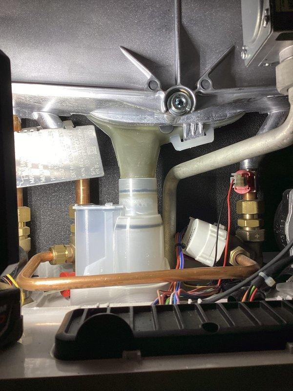 Responded to service call for boiler leaking water with active low pressure light. Upon inspection, identified loose condensate trap that had been previously replaced. Tightened the screw-on trap securely, resolving the leak issue. System returned to normal operation with no further adjustments needed.