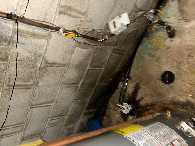 Responded to service call for reported toilet leak. Upon inspection, determined issue was not with toilet but identified pinhole leak in main water line above water meter that was spraying at wall. Completed repair by replacing affected section of pipe and installing new ball valve.