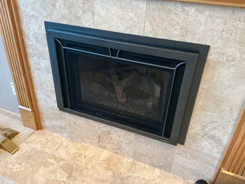 Minnetonka, MN - Responded to client request for gas line evaluation at fireplace following third-party identification of potential leak. Visual inspection of gas fireplace unit with black metal frame, glass front, and artificial logs confirmed presence of gas supply issue. Advised client to proceed with Fireside's repair bid as originally recommended.