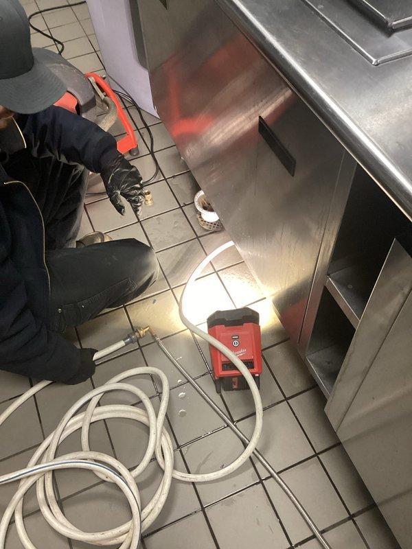 Responded to recurring main drain backup issue in commercial kitchen. Diagnosed sugar buildup causing floor drain clog, then utilized drain cable to clear the line and restore proper drainage function. Inspected associated under-sink plumbing to verify complete system functionality.