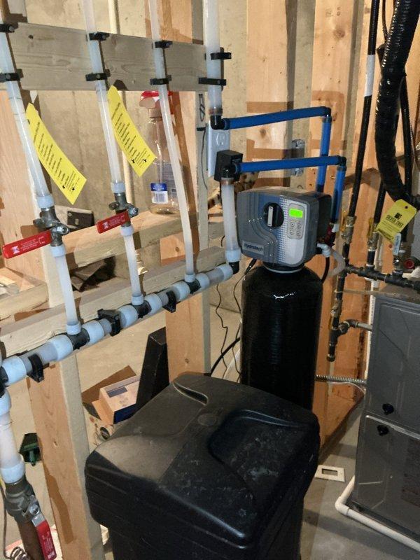 Responded to no hot water complaint for 4-year-old water heater (potentially under manufacturer warranty). Diagnosed issue as tripped GFI outlet affecting system operation. Restored hot water service by resetting GFI. Inspected ventilation system and water treatment equipment, noting proper installation of RenewAire unit with connected flexible metallic ducts and functional water filtration system with control panel.