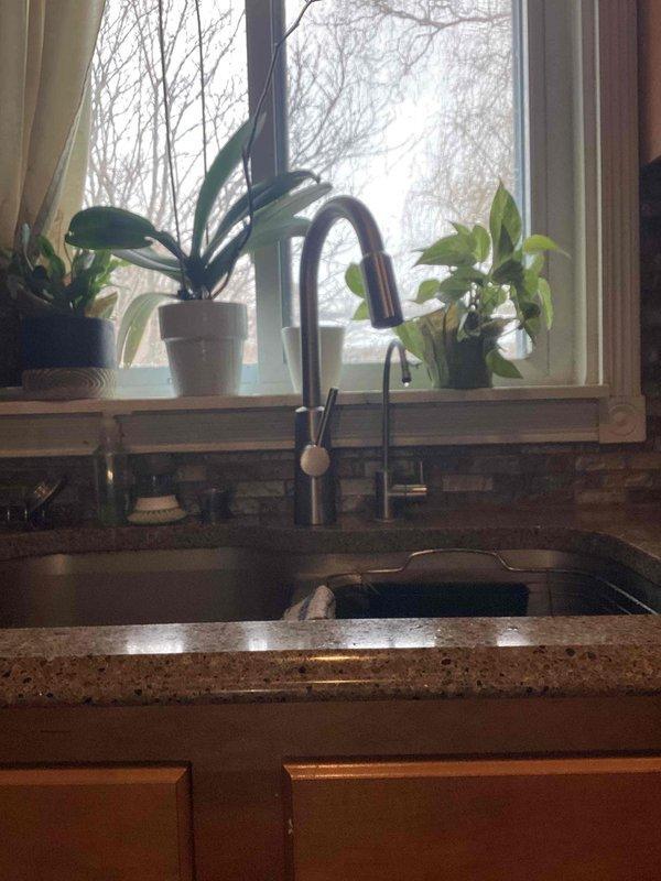 Successfully installed customer-supplied kitchen faucet with pull-down sprayer feature on granite/quartz countertop. Replaced reverse osmosis filtration system with customer-supplied components, ensuring proper connection of all colored tubes to the transparent filter housing and pressurized tank. Repaired hot water line in downstairs bathroom to restore proper functionality.