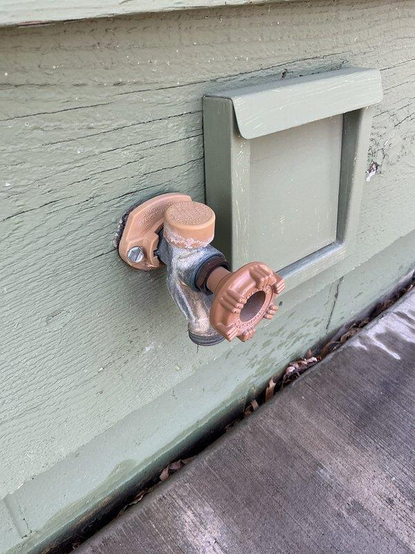Replaced defective exterior hose bib (spigot) and faulty shower valve cartridge. The outdoor copper spigot mounted on the building's exterior wall was removed and replaced with a new frost-free unit, and the interior shower valve cartridge was replaced to restore proper water flow and temperature control.