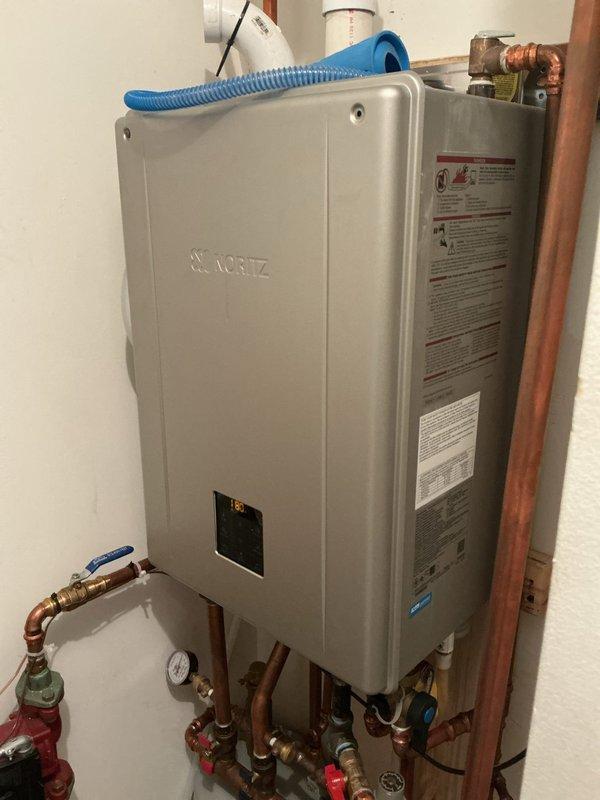 Responded to no heat/no hot water call for Noritz tankless water heater system with in-floor heating. Diagnostic inspection revealed heat exchanger with critical failure - plugged, cracked, with external penetration. System deemed unsafe to operate due to compromised heat exchanger integrity. Advised customer that unit is under manufacturer warranty through Hero and they will initiate warranty claim process.