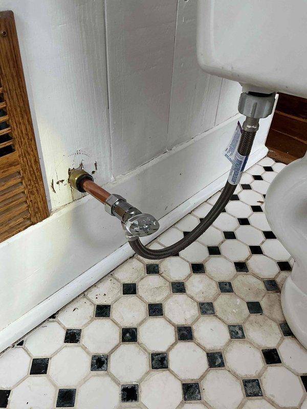 Responded to a water leak emergency in the kitchen originating from the bathroom above. Upon inspection, discovered a faulty SharkByte toilet supply line connection causing the leak. Replaced the defective supply line and verified proper operation with no further leakage.
