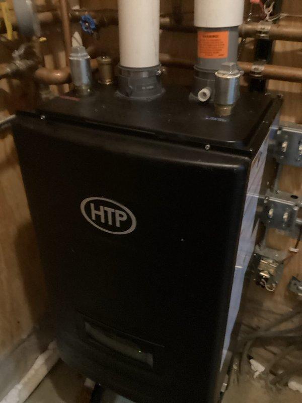 Responded to service call for non-functional upper level heat and system noise. Found low water pressure causing excessive wear on primary pump and air-locked zone pumps. Added water to system, purged air from loops, and restored proper pump operation. Set system pressure to 17 psi. Noted discolored water with oxygen bubbles throughout system. Recommended Fernox Treatment and replacement of primary pump due to wear.