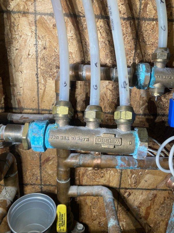 Inspected aging boiler system with leaking in-floor heating pump manifold at connection points. Identified blue sealant failure on KISSCO manifold with PEX distribution pipes. System is approximately 10+ years old with multiple obsolete components. After consultation with customer and colleague Dylan, recommended full boiler replacement and repiping due to system age and condition. Scheduled service advisor visit for replacement options and pricing.