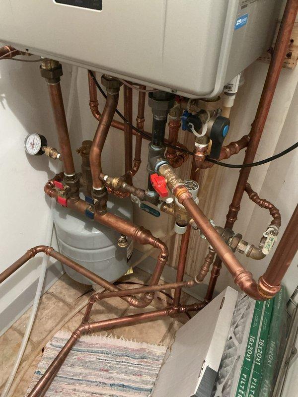 Responded to no heat/no hot water call for Noritz tankless water heater system with in-floor heating. Diagnostic inspection revealed heat exchanger with critical failure - plugged, cracked, with external penetration. System deemed unsafe to operate due to compromised heat exchanger integrity. Advised customer that unit is under manufacturer warranty through Hero and they will initiate warranty claim process.