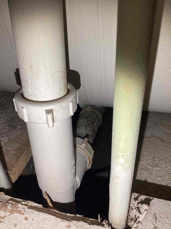Diagnosed water leak issue originating from bathroom tub. Inspection revealed faulty toe kick slider with deteriorated gasket causing water to seep through to lower level bathroom ceiling when tub was clogged with standing water. Documented plumbing system with photos showing PVC drainage pipes and corroded copper supply line. Provided estimate for replacement of toe kick and arm components to resolve the leak.