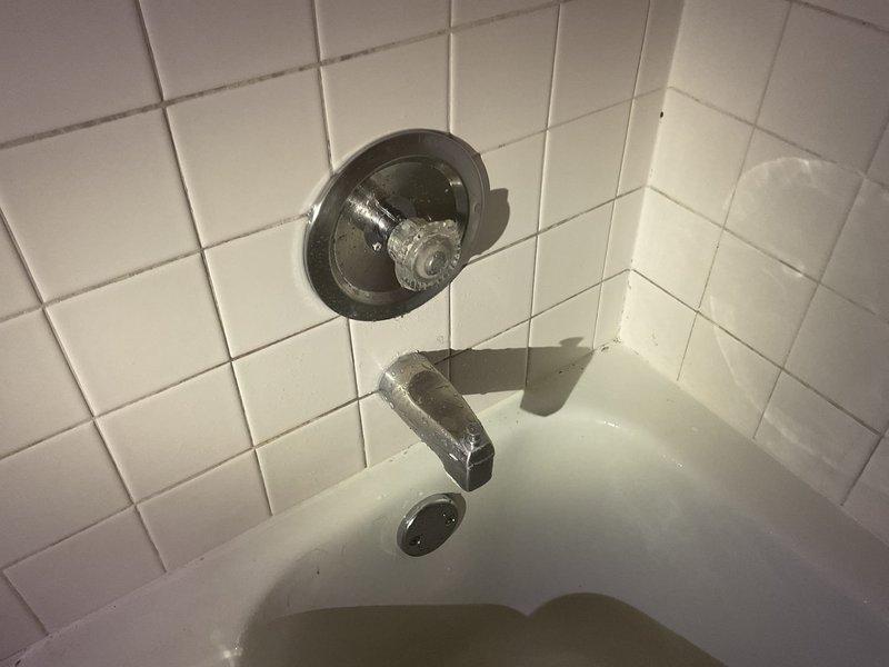 Responded to active water leak behind bathtub and shower wall. Upon investigation, identified failed Moen 1225 cartridge leaking from the stem, with water traveling back into the valve sleeve and causing water intrusion behind the tub/shower assembly and along drain piping. Removed defective cartridge and installed new Moen 1225 replacement cartridge. Performed operational testing to verify proper function and confirm leak elimination.