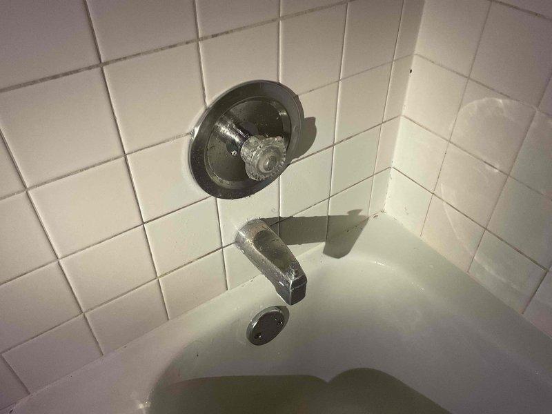 Responded to active water leak behind bathtub and shower wall. Upon investigation, identified failed Moen 1225 cartridge leaking from the stem, with water traveling back into the valve sleeve and causing water intrusion behind the tub/shower assembly and along drain piping. Removed defective cartridge and installed new Moen 1225 replacement cartridge. Performed operational testing to verify proper function and confirm leak elimination.