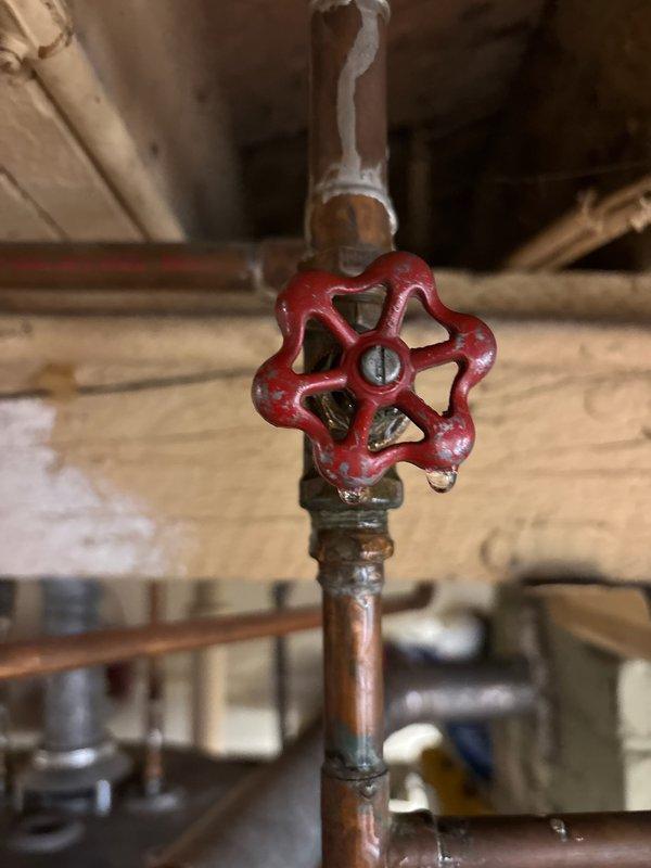 Responded to emergency water leak caused by failed valve on cold water supply line to water heater. Main water supply was shut off upon arrival to prevent further damage. Removed defective valve and installed new ball valve on cold side of water heater using proper copper pipe connections. New valve was left in closed position after installation due to separate leaking condition identified on the water heater tank itself, which had been previously estimated for replacement with a power vent unit to accommodate existing chimney configuration.