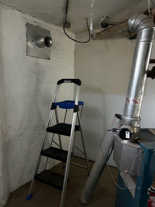 Responded to no-heat callback on residential boiler system. Upon arrival, confirmed boiler was non-operational due to blocked chimney flue preventing proper venting. Inspected venting system and documented obstructed condition with photos showing the boiler unit, associated piping infrastructure, and vertical flue pipe configuration. Customer had already arranged for chimney service contractors to address the blockage. Verified boiler safety controls were functioning properly and system was in lockout mode as designed due to inadequate draft conditions. Explained situation to customer and confirmed chimney professionals would resolve the venting obstruction to restore safe operation.