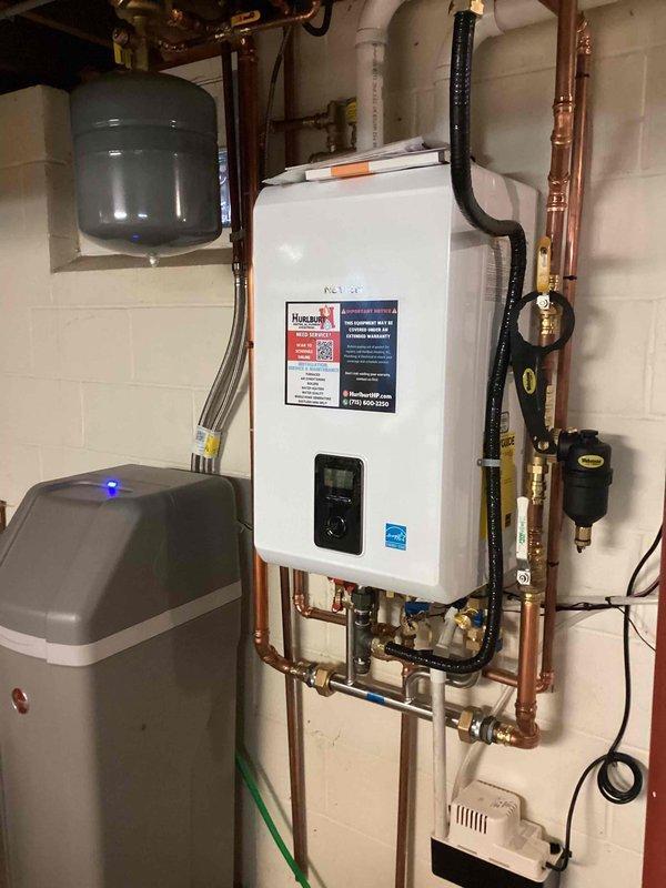 Performed comprehensive plumbing inspection of residential water heating and treatment system, including tankless water heater, water softener unit, expansion tank, and associated copper piping network with brass valves and fittings. All components inspected and found to be functioning properly with no deficiencies identified; no repairs or adjustments required at this time.