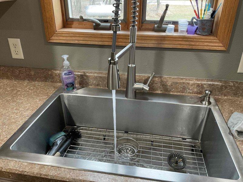 Responded to kitchen sink plumbing issues involving low hot water pressure and a leaking basket strainer. Removed and replaced the defective basket strainer with a new unit, ensuring proper seal and installation. Cleared debris from the hot water supply tube connected to the kitchen faucet, which was restricting flow and causing the reduced pressure. Tested both hot and cold water flow after repairs to verify proper operation and confirmed no leaks at the basket strainer or supply connections.