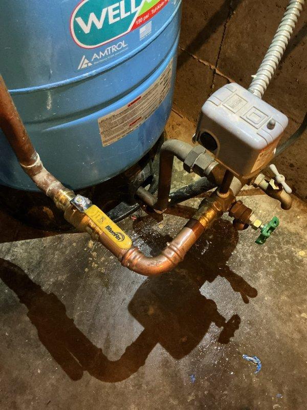 Responded to service call for leaking ball valve near AMTROL water pressure tank in basement. Identified source of leak causing water puddles on concrete floor. Replaced damaged ball valve and small section of connecting copper pipe to resolve the slow drip that customer reported had been ongoing for approximately two years.