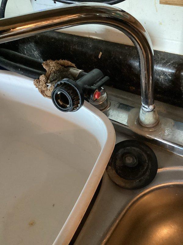 Installed customer-supplied water heater in mobile home, converting from electric to gas system. Observed significant mineral/sediment buildup around kitchen faucet and provided estimate for replacement, which customer declined.